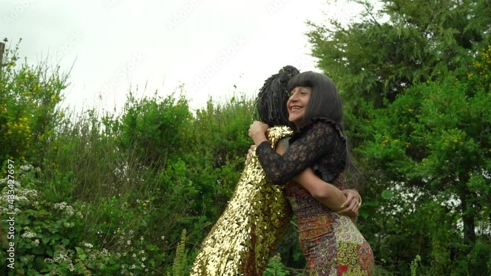 Mujeres transgénero abrazándose una a otra en medio de la vegetación del bosque 