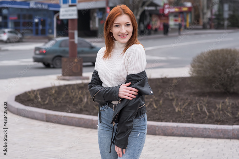 Portrait of a beautiful and positive redhead woman with clothes in grunge style. Posing while walking Portrait of a beautiful and positive redhead woman with clothes in grunge style. Posing while walking