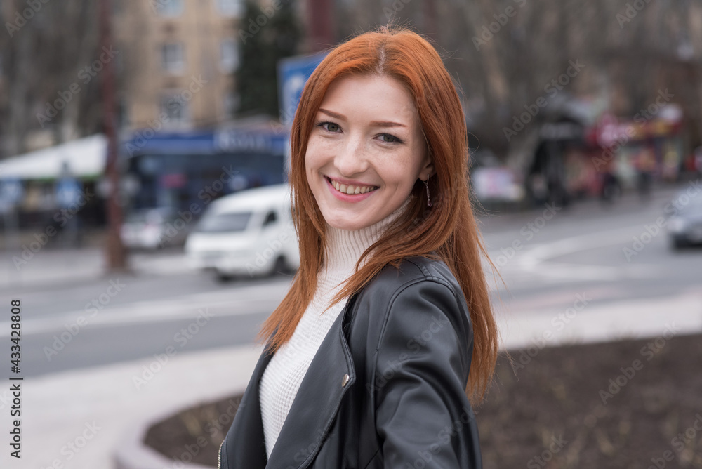 Fototapeta premium Portrait of a beautiful and positive redhead woman with clothes in grunge style. Posing while walking
