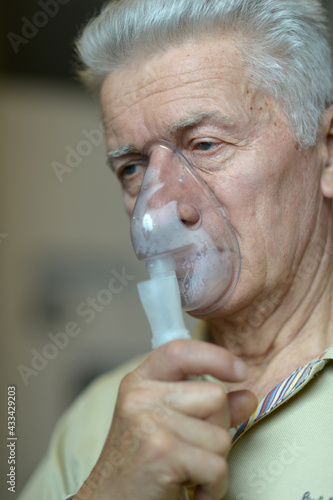 Portrait of  sick senior man with inhaler