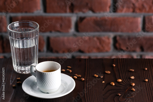 A cup of espresso macchiato with glass of water photo