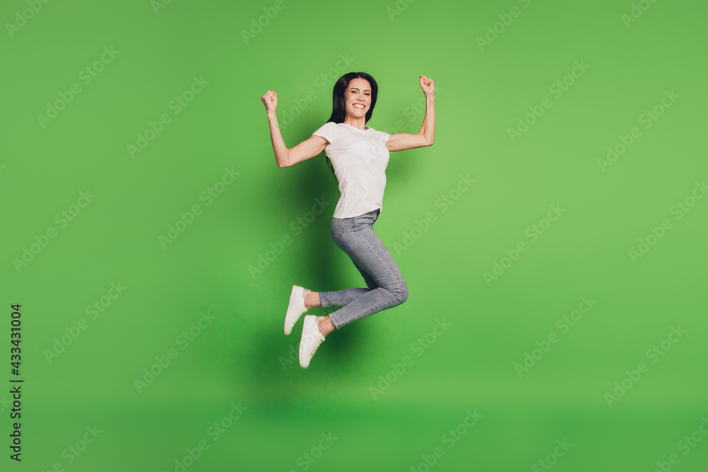 Full size photo of jumping woman over green background Full size photo of jumping woman over green background