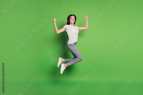Full size photo of jumping woman over green background