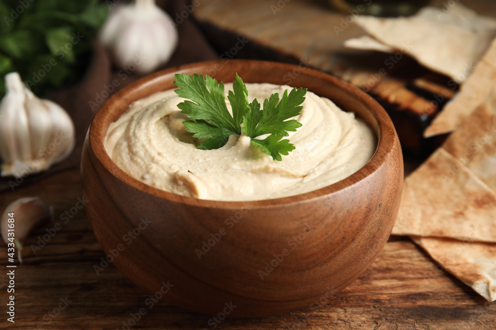 Delicious hummus and pita chips on wooden table, closeup Delicious hummus and pita chips on wooden table, closeup