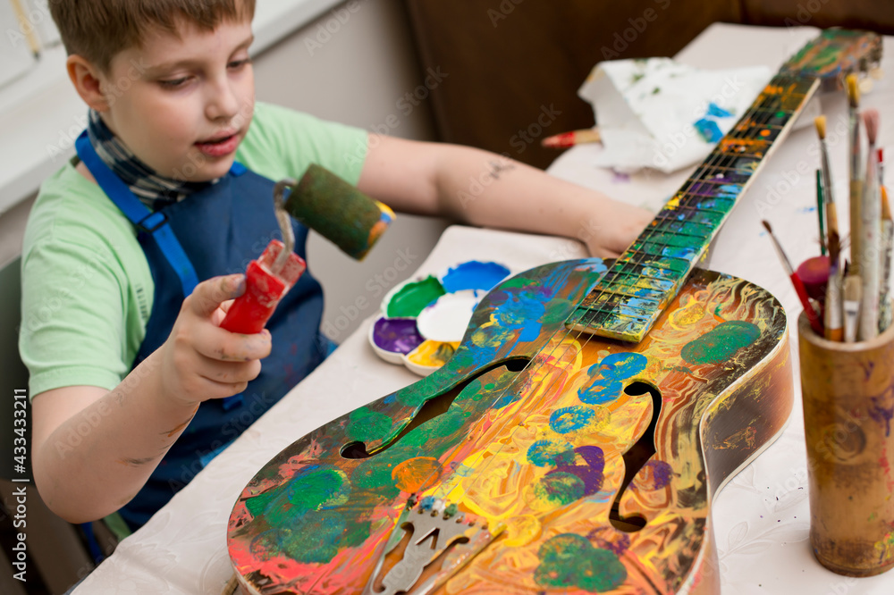 Kid have fun painting guitar. Color gouache art therapy lesion. Kid have fun painting guitar. Color gouache art therapy lesion.