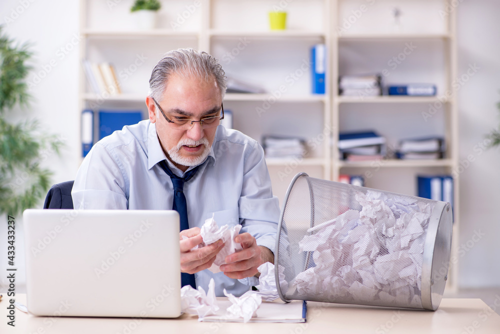 Fototapeta premium Old businessman rejecting new ideas with lots of papers