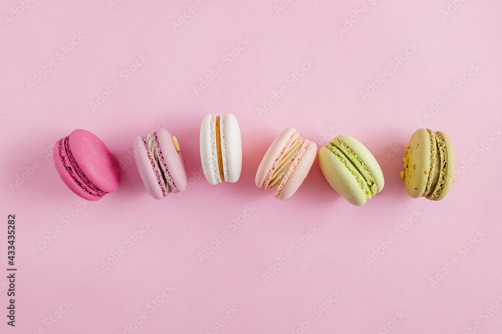 Colorful dessert macarons on pastel pink background Colorful dessert macarons on pastel pink background