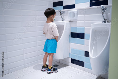 A boy is pissing himself in the bathroom. photo