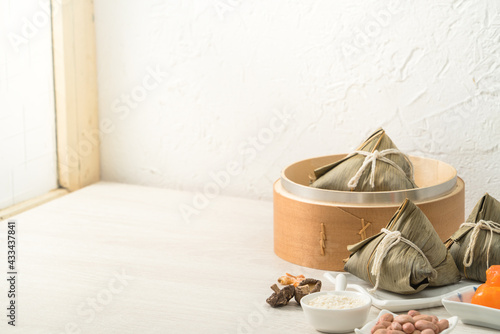 Zongzi. Rice dumpling for Dragon Boat Festival on bright wooden table background with window.