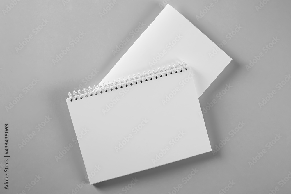 Blank brochure and notebook on grey background, flat lay. Mockup for design Blank brochure and notebook on grey background, flat lay. Mockup for design