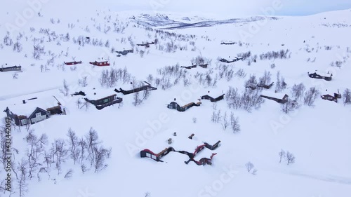 Panorama over Beitostølen village and ski resort with cozy log cabins on a cloudy winters day.