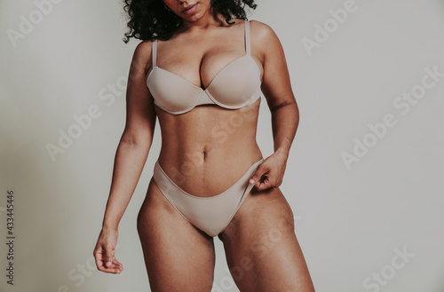 Body acceptance concept.  curvy girl posing in studio against society prejudice photo