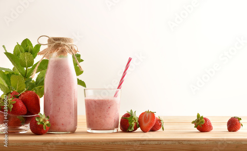 Strawberry shake on table with basket full of fruits