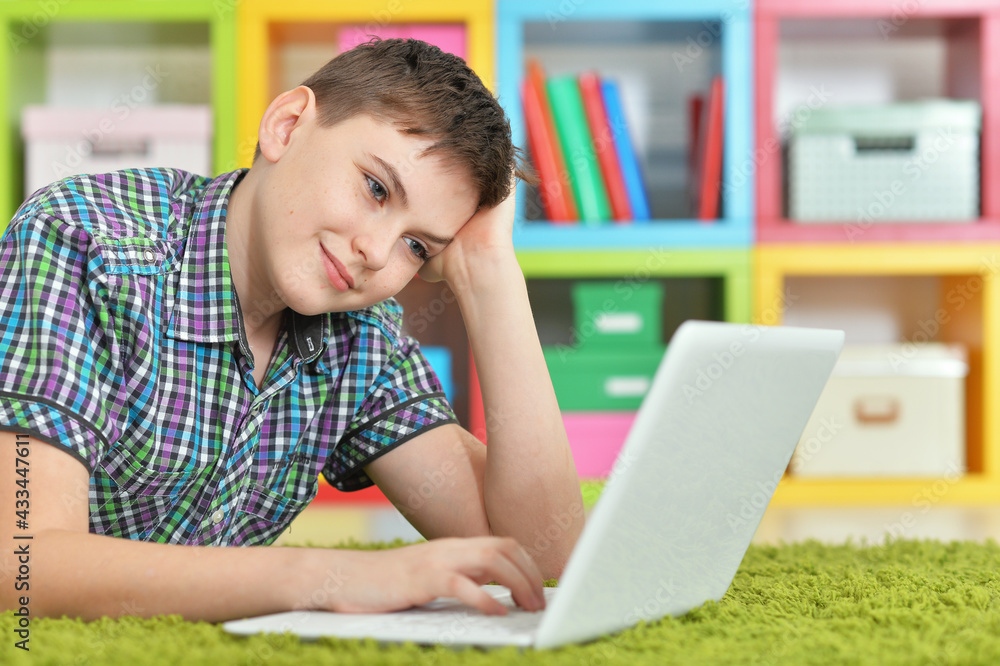 Little boy using laptop while lying on floor Little boy using laptop while lying on floor