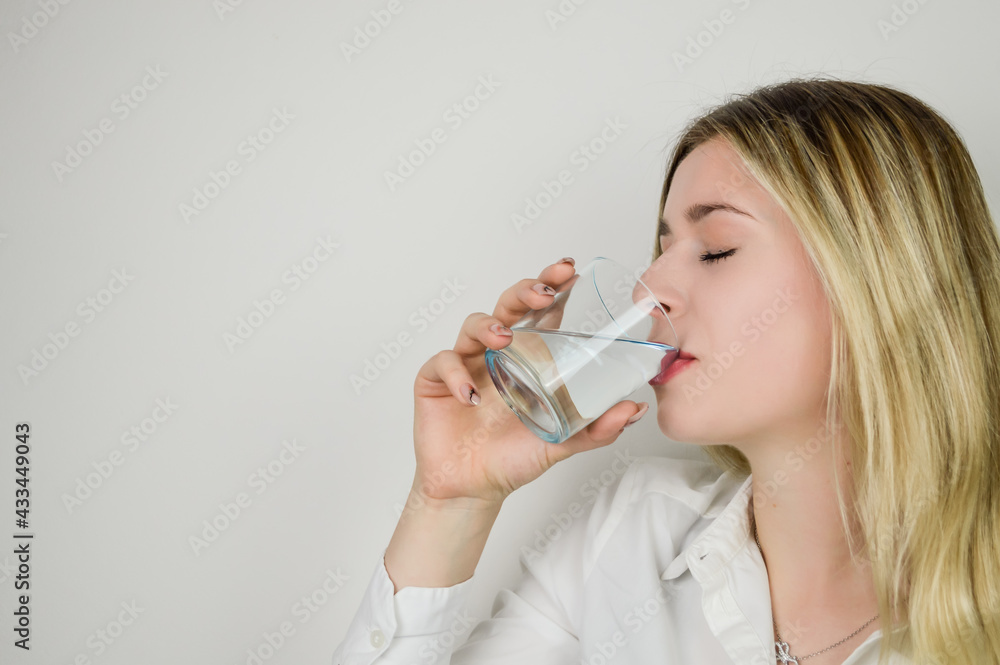Portrait of a beautiful young blonde woman drinking a glass of water Portrait of a beautiful young blonde woman drinking a glass of water