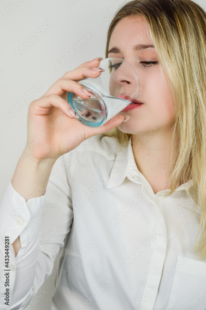 Portrait of a beautiful young blonde woman drinking a glass of water Portrait of a beautiful young blonde woman drinking a glass of water