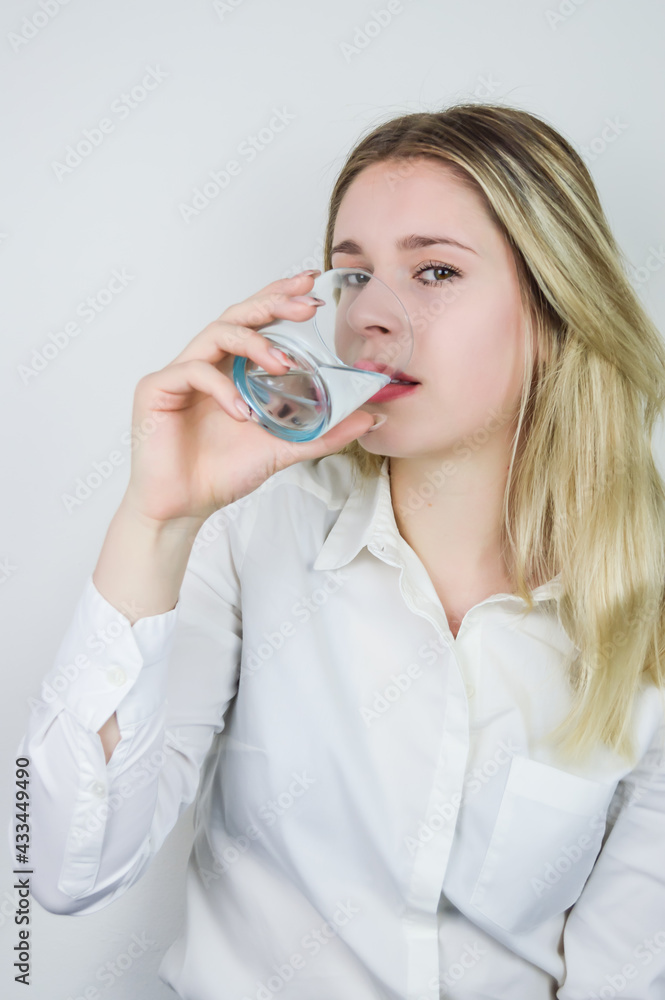 Portrait of a beautiful young blonde woman drinking a glass of water Portrait of a beautiful young blonde woman drinking a glass of water
