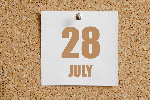 july 28. 28th day of the month, calendar date.White calendar sheet attached to brown cork board.Summer month, day of the year concept photo