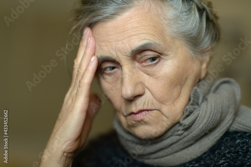 Close up portrait of sad ill senior woman with headache