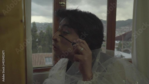 Joven queer maquillándose frente al espejo de su habitación 