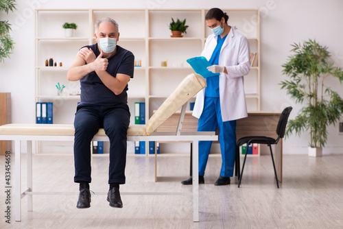 Old man visiting young doctor in covid-19 vaccination concept © Elnur