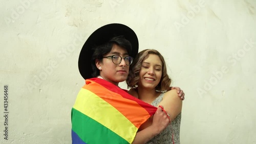 Amigos LGTBQ abrazados sostienen la bandera LGTBQ en la calle