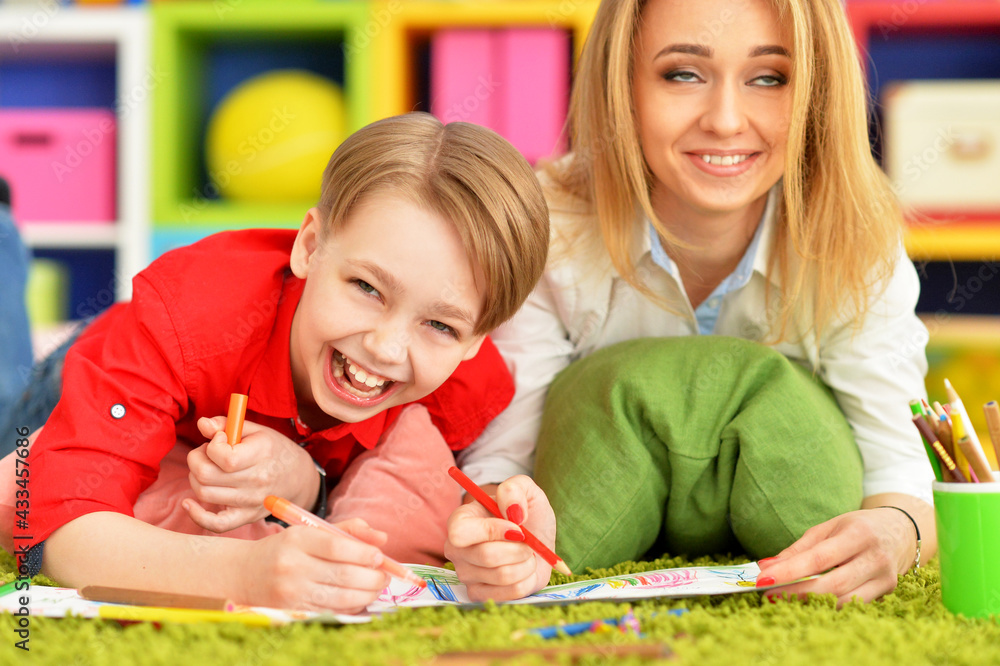 Close up view of smiling mother and son drawing with pencils Close up view of smiling mother and son drawing with pencils