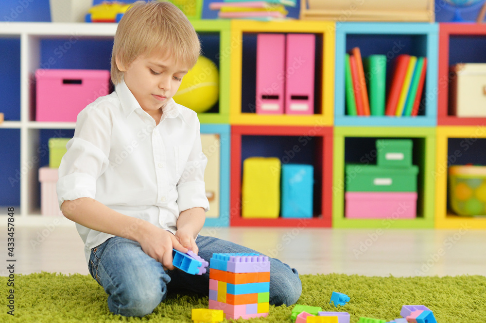 Cute little boy playing with colorful plastic blocks Cute little boy playing with colorful plastic blocks