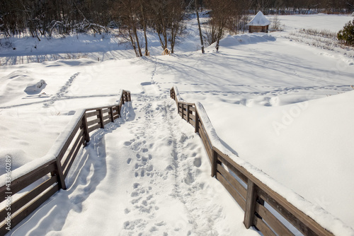 Snow-covered stairs from the hill to the river bank