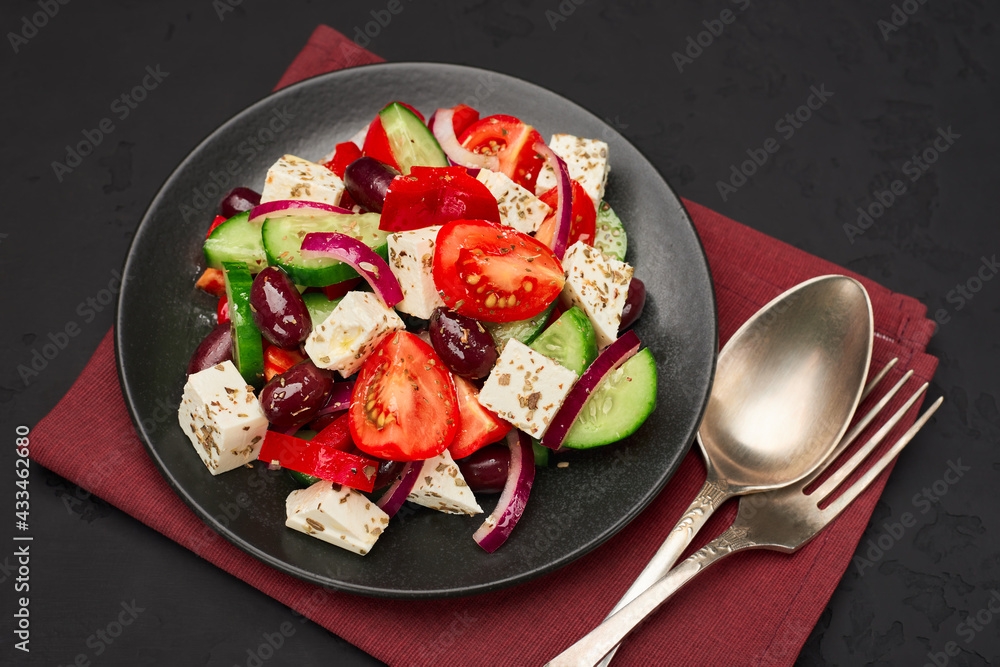 Top view plate of classic greek salad on napkin with cutlery