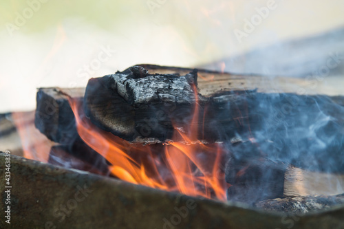 a Burning firewood in the fireplace close up, BBQ fire, charcoal background. Charcoal fire with sparks