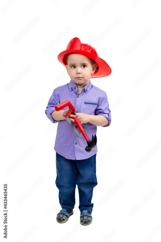 Three-year-old boy in a red helmet with toys in his hands, isolated.
