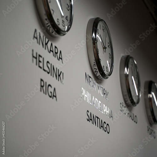 Obraz na płótnie Many wall clocks on the white wall of business office showing time of different cities of the world w salonie