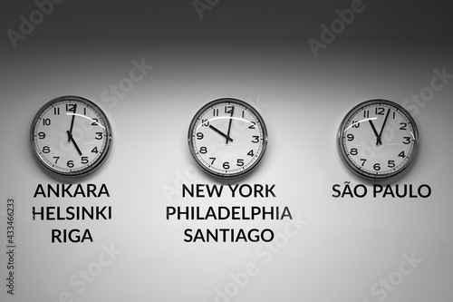 Obraz na płótnie Many wall clocks on the white wall of business office showing time of different cities of the world w salonie