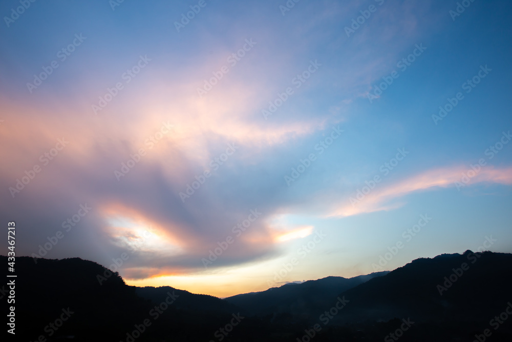 Clouds in the sky, beautiful shape in the evening, white and orange On the shadow of the mountain Blue background Beautiful landscapes for background images.