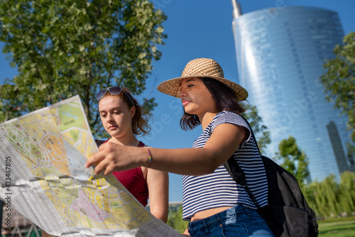 Obraz na plátně Couple of young lesbian woman looking at map of the city for urban exploration,