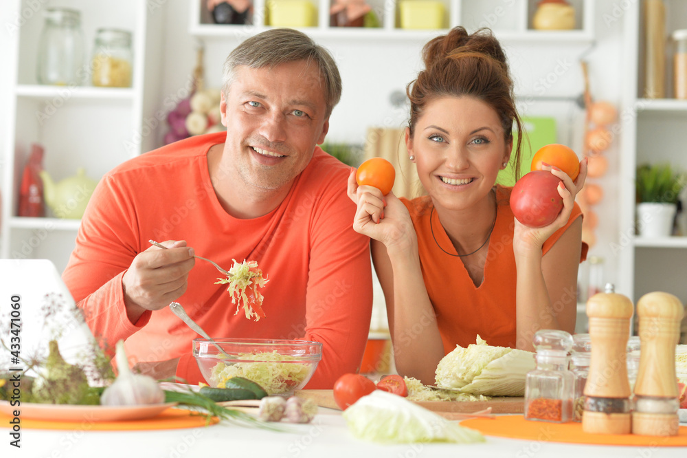 Happy married couple cooking together on kitchen Happy married couple cooking together on kitchen