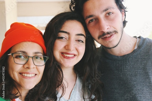 Foto three young friends of turkish ethnicity looking at camera smiling at outdoors h