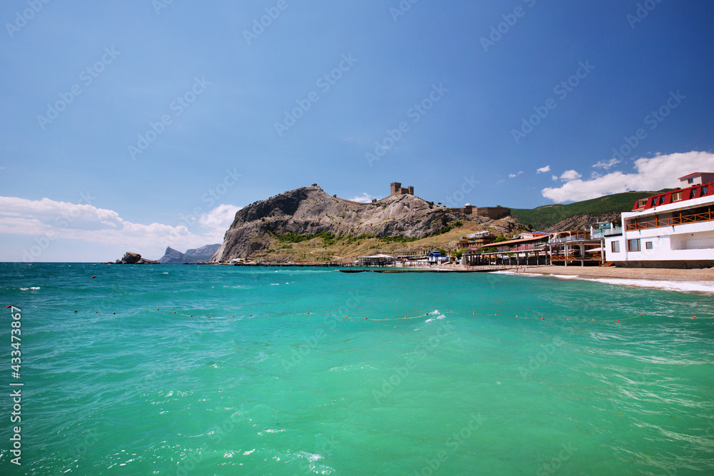 View of the Genoese fortress in Sudak, Crimea. Azure sea. Blue sky.