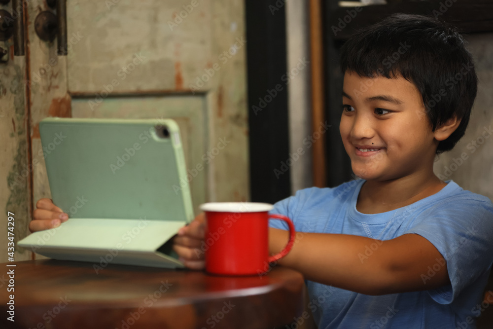 Young boy is studying in front of the laptop. E learning, study at home online. Happy smile time Asians boy is using a laptop and communicates on the Internet at home. homeschooling, distant learning. Young boy is studying in front of the laptop. E learning, study at home online. Happy smile time Asians boy is using a laptop and communicates on the Internet at home. homeschooling, distant learning.