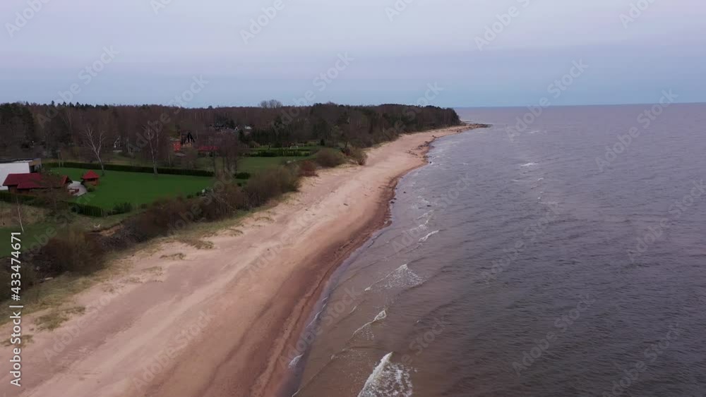 Peaceful seaside properties on beach, aerial dolly in drone shot