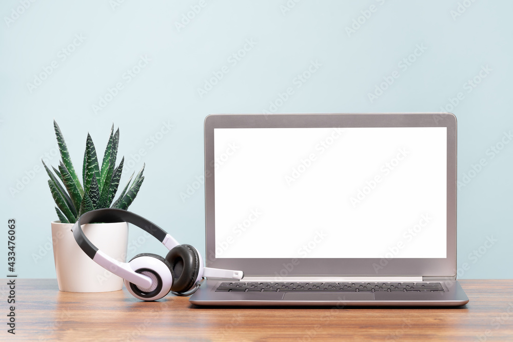Laptop. Mockup blank screen and headphones on wooden desk. Distant learning. working from home, online courses or support minimal concept. Helpdesk or call center headset - obrazy, fototapety, plakaty 