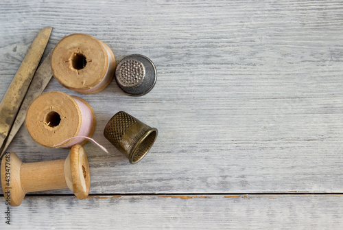 Photography Set of vintage sewing spools, scissors and partner thimbles.
