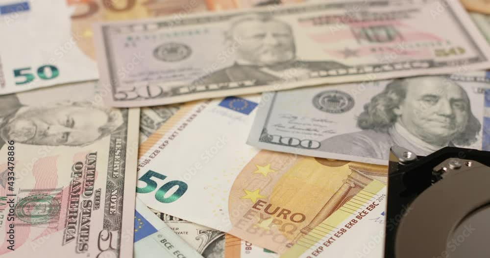 Panning over Dollar and Euro Banknotes towards HDD with Bitcoin reflecting on Hard Drive Platter. Bitcoin reflection in focus Panning over Dollar and Euro Banknotes towards HDD with Bitcoin reflecting on Hard Drive Platter. Bitcoin reflection in focus