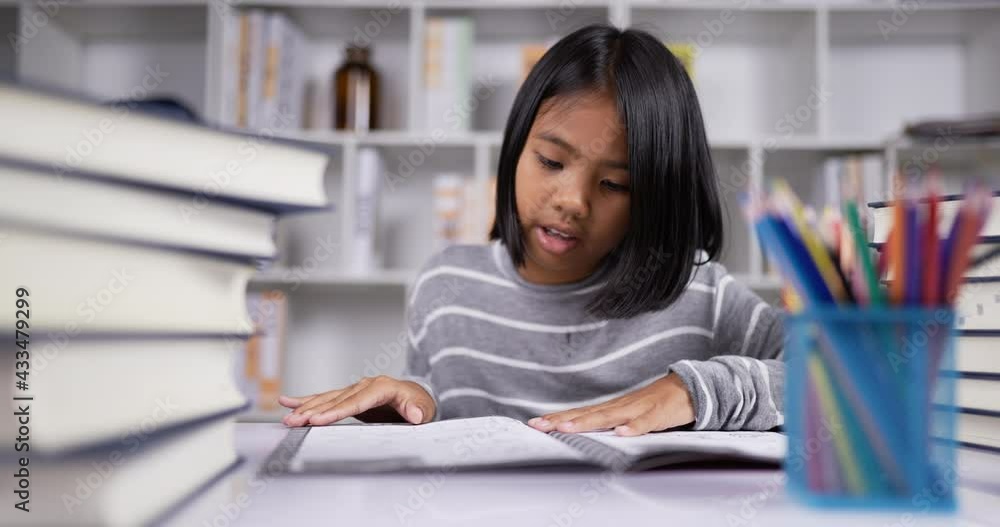 Asian short hair girl reading at the desk at classroom. Asian short hair girl reading at the desk at classroom.