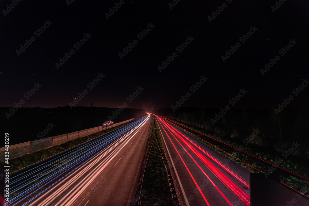 smugi świateł samochodów na autostradzie w ciemną noc - obrazy, fototapety, plakaty 