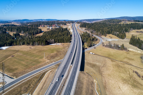 Old road and new highway from Krakow to Zakopane in Poland, called Zakopianka with viaducts, elevated crossroads and cars. Aerial view in winter