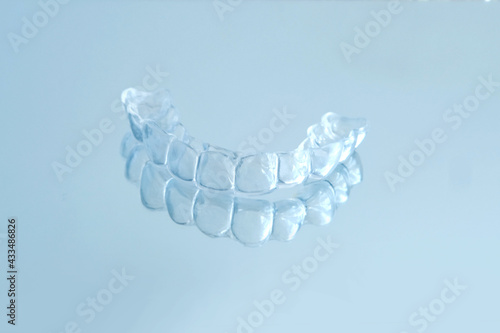 close-up of transparent Silicone Night Mouth Guard for Teeth Clenching Grinding Dental Bite Sleep Aid on a blue background, concept dental services, remedy for grinding teeth, oral care