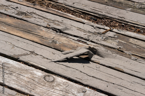 Wood deck with damaged boards and peeling deck paint; power washing, refinishing, and board replacement needed