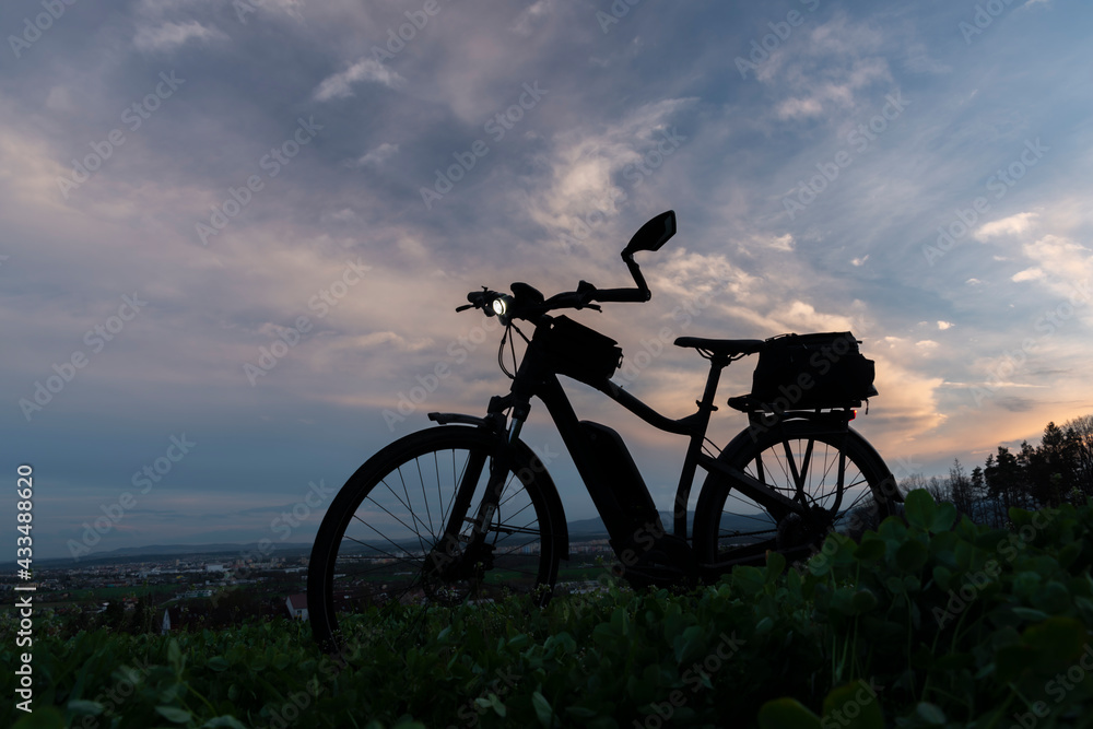 Fototapeta premium Black and gray electric bicycle in sunset time with cloudy sky